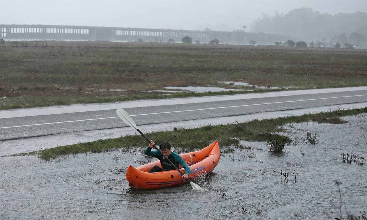 Un estudiante de la secundaria Tamalpais utiliza un kayac para cruzar una zona inundada.