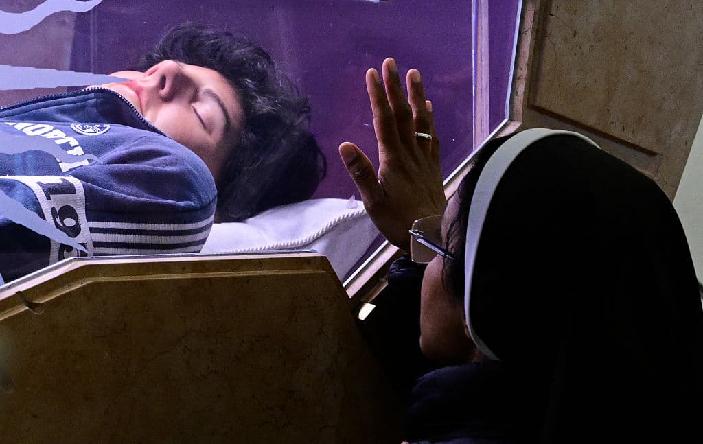 Contenido gráfico / Una monja reza ante la tumba del beato Carlo Acutis.