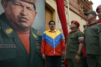 Nicolás Maduro con la imagen de Hugo Chávez de fondo.