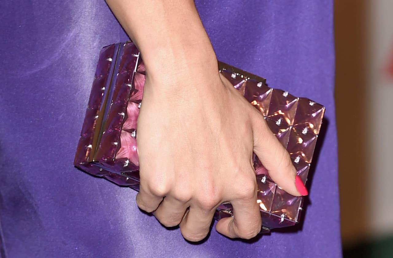 Un gran toque fue su pequeño bolso con detalles en acrílico y color violeta.