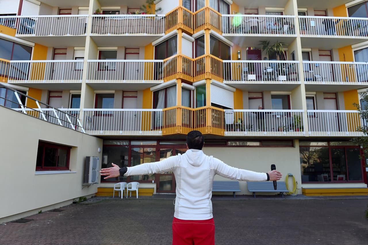 Otros buscan la manera de continuar con sus actividades habituales pese al encierro. En la foto, el preparador físico Sebastien Manko da una lección a personas mayores que hacen gimnasia desde los balcones de su casa de retiro en Burdeos.