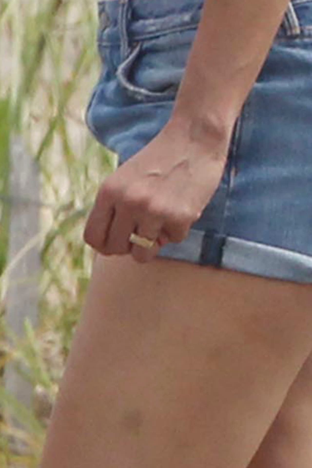 Un acercamiento a la fotografía de 
<b>la mano de <a href="https://www.univision.com/entretenimiento/chismes/jennifer-lopez-es-una-presumida">Jennifer</a></b> (sí la mano donde se lleva ese símbolo de unión) no permite zanjar la controversia. Solo se observa una imagen distorsionada de una sortija dorada. No se nota el típico brillante, que delata los 
<b>anillos de compromiso</b>. No queda claro si el anillo está girado (y por eso no se ve el brillante), o si el diseño es plano en su parte superior.