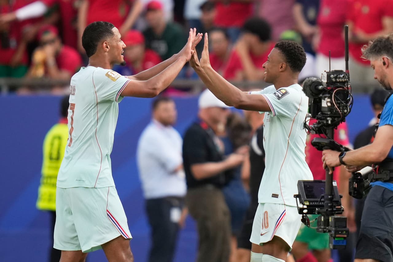 William Saliba festeja con Kylian Mbappe.
