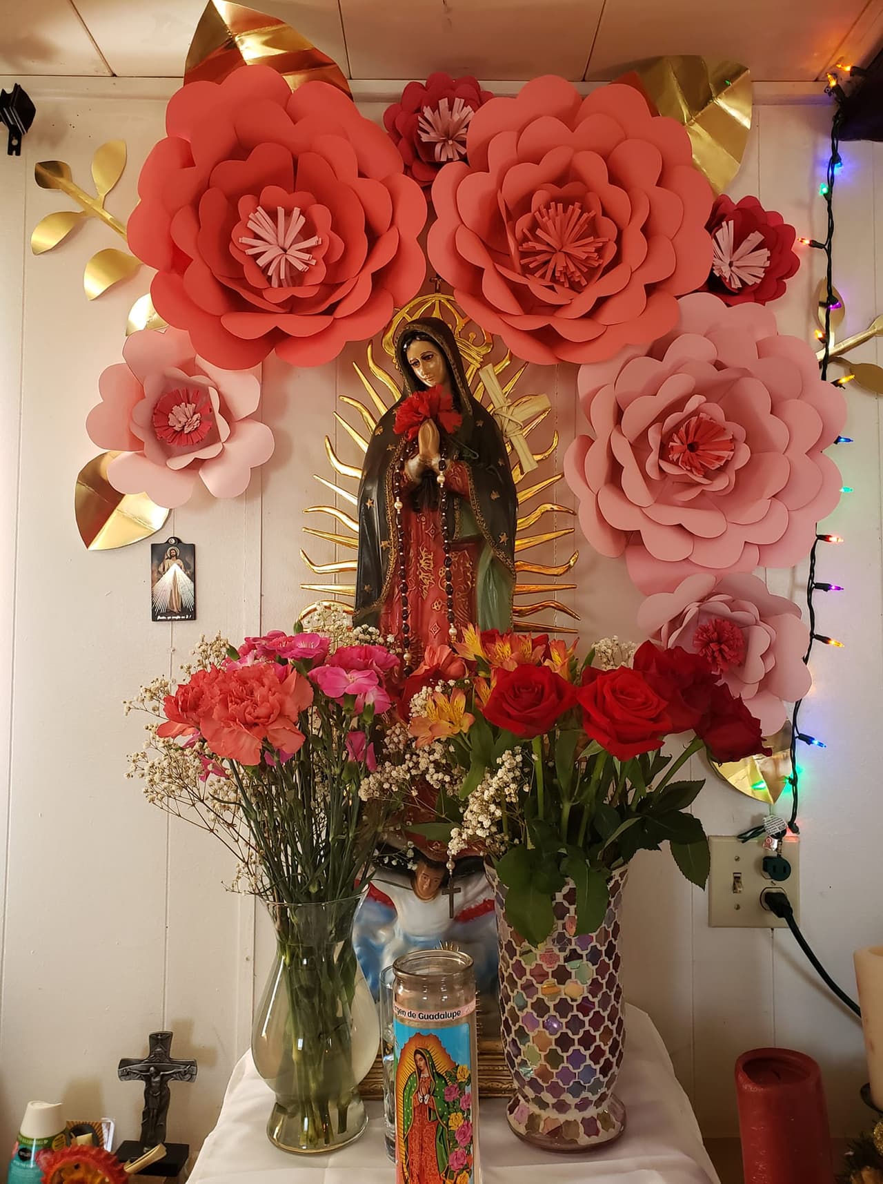 Con enormes flores de papel en tonos rosa claro, así decoró Martha Padilla el altar a la Virgen de Guadalupe, que lo hace ver especial.