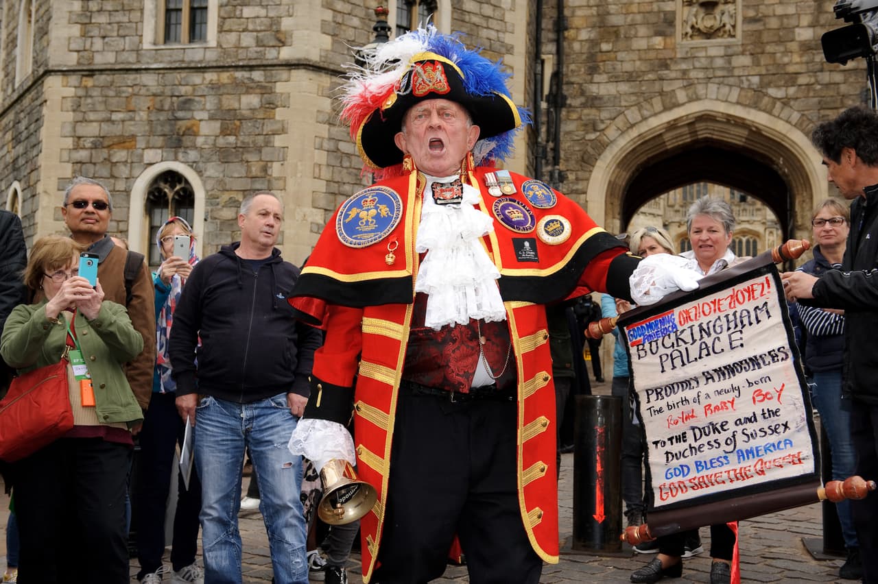 Frente al castillo de Windsor, este vocero proclamó a viva voz que ya 
<b><a href="https://www.univision.com/famosos/meghan-markle-dio-a-luz-en-un-hospital-y-no-en-su-casa-a-donde-reportan-que-regreso-pronto">Meghan Markle, duquesa de Sussex, había dado a luz</a></b> a un varón. "Dios bendiga América" y " Dios salve a la Reina" se leía en la pancarta donde también informaba el nacimiento del primer hijo del príncipe Harry con la retirada actriz estadounidense.