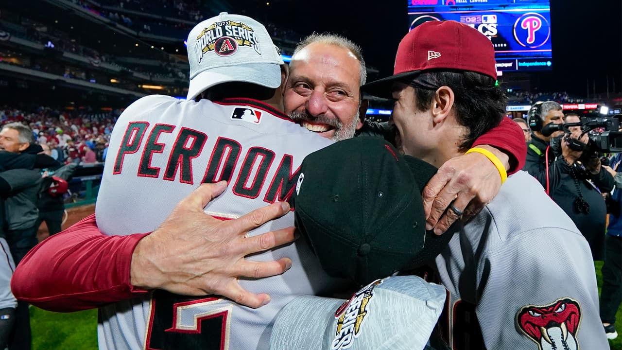 Torey Lovullo, mánager de los Diamondbacks de Arizona, abraza a los peloteros Geraldo Perdomo y Corbin Carroll.