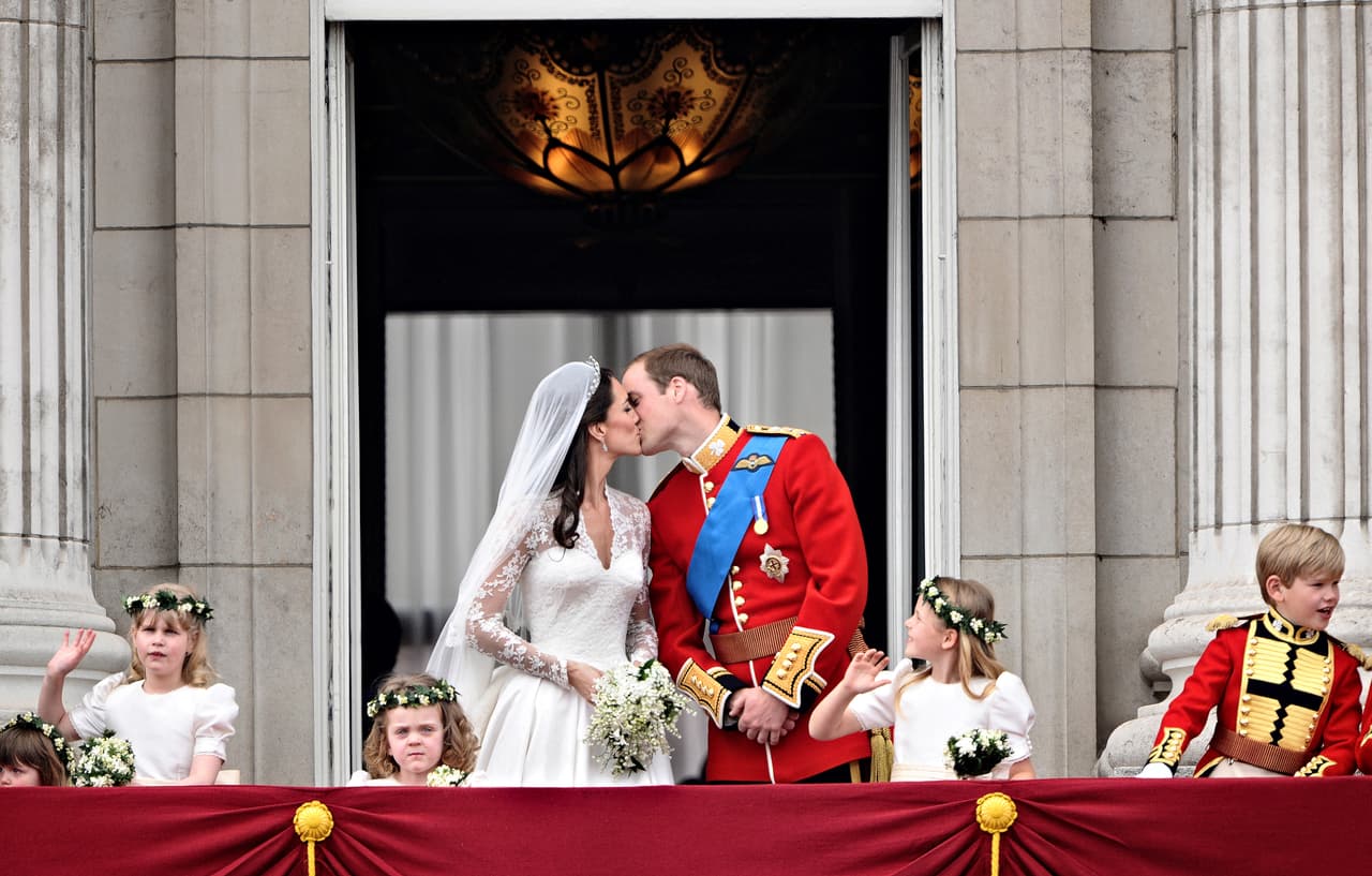 Los duques de Cambridge, recién casados y sonrientes, saludaron a los ingleses desde el balcón del Palacio de Buckingham después de su boda el 29 de abril de 2011 y allí quedó inmortalizado un beso.