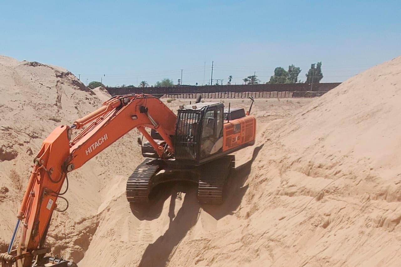 La máquina excavadora utilizada en el hallazgo, al fondo la valla fronteriza entre EEUU y México. El descubrimiento fue el resultado de una colaboración entre varias agencias encabezadas por HSI y, por el momento, no se reporta ninguna persona
<a href="https://www.univision.com/temas/arrestos"><b>arrestada</b></a>.
<br>