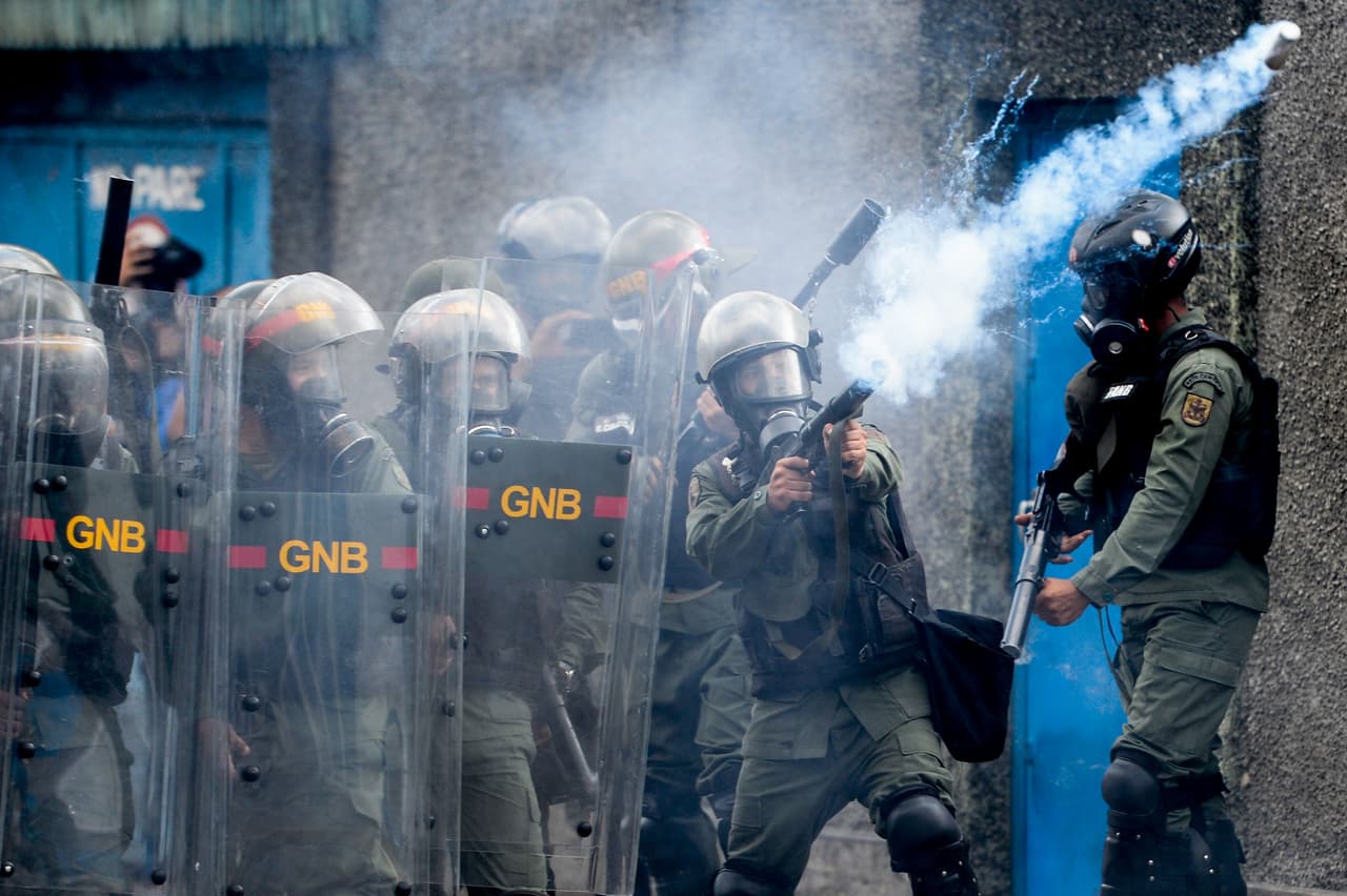 Soldados de la Guardia Nacional disparan gases lacrimógenos contra los manifestantes que protestan contra Nicolás Maduro.