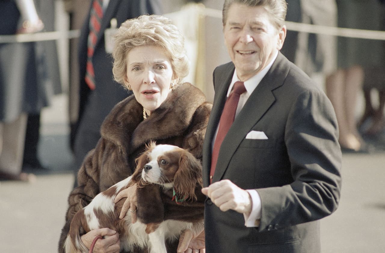 Ronald Reagan gobernó de 1981 hasta 1989 y tuvo en total seis perros. En la fotografía junto a su esposa y un cachorro que le dio de regalo de navidad en 1985.
