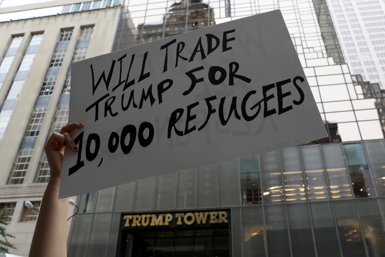 "Cambiamos a Trump por 10,000 refugiados", se lee en esta otra pancarta desplegada en Manhattan. (Shannon Stapleton/Reuters)