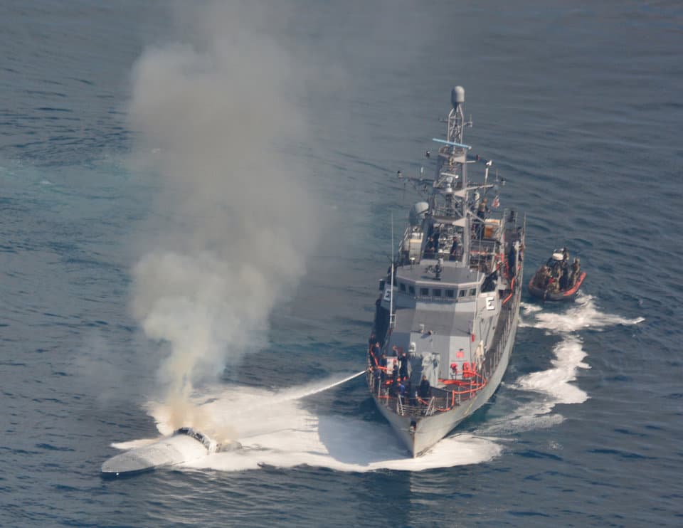 La tripulación del buque USS Zephyr apagaba un incendio en una nave semisumergida usada para el contrabando de droga en el Océano Pacífico el 7 de abril de 2018.