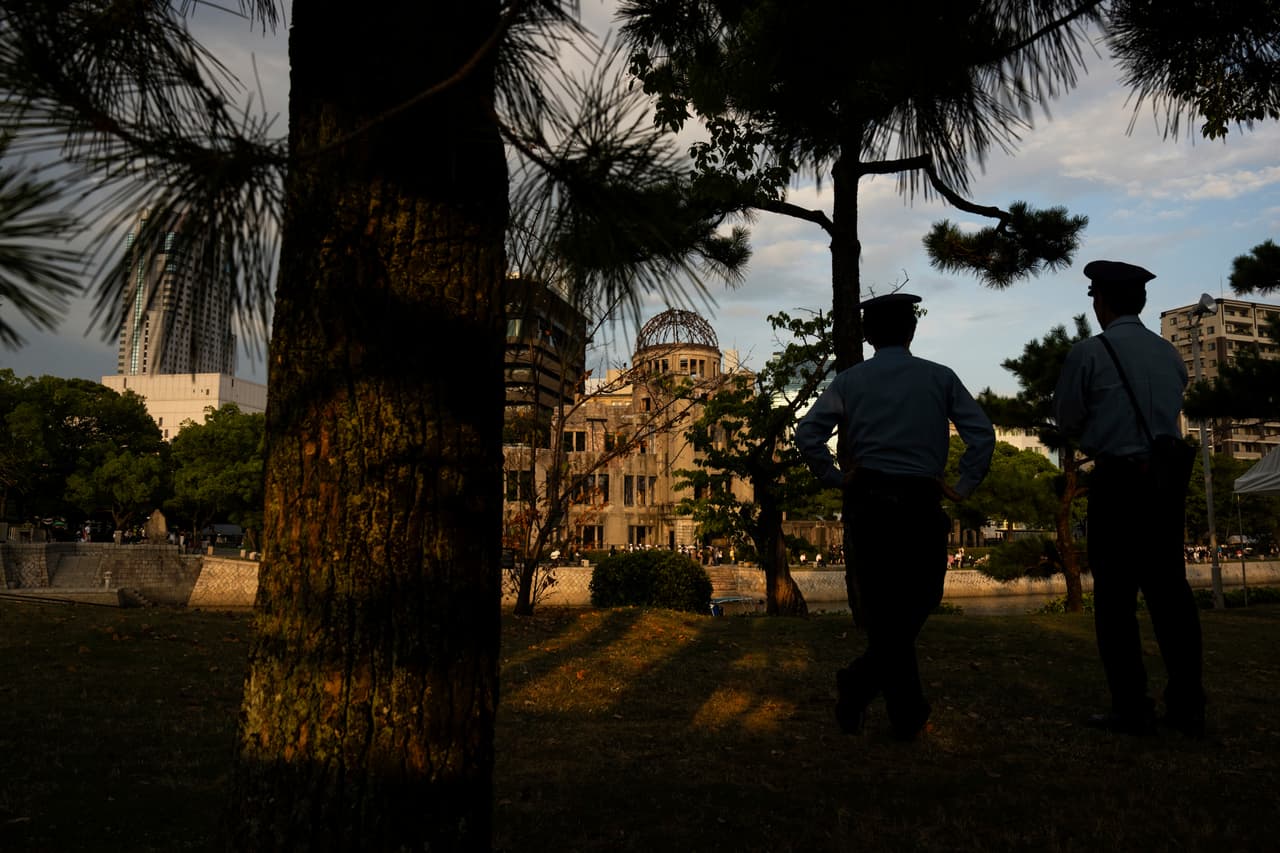 Policías patrullan el Parque Conmemorativo de la Paz con la Cúpula de la Bomba Atómica al fondo, en Hiroshima.
