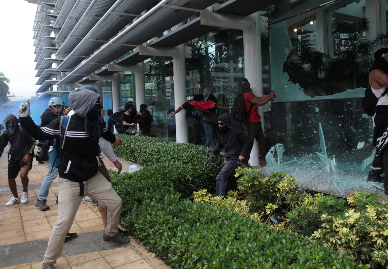 Luego de que concluyeron las marchas, un grupo rompió vidrios y pintó paredes de algunos bancos y negocios en el área de la Milla de Oro. (Reuters)