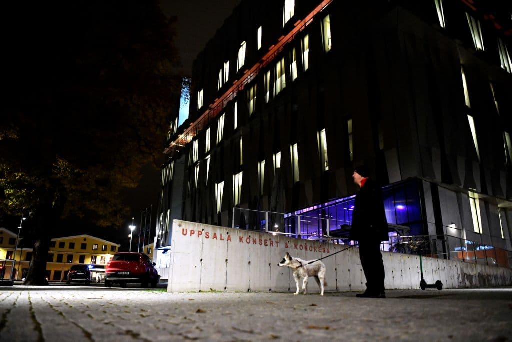 Un hombre pasea a su perro frente a la sala de conciertos "Uppsala Konsert & Kongress" en Uppsala, Suecia, el 2 de noviembre de 2021. Dos personas murieron en el interior tras caer una de ellas de un séptimo piso.