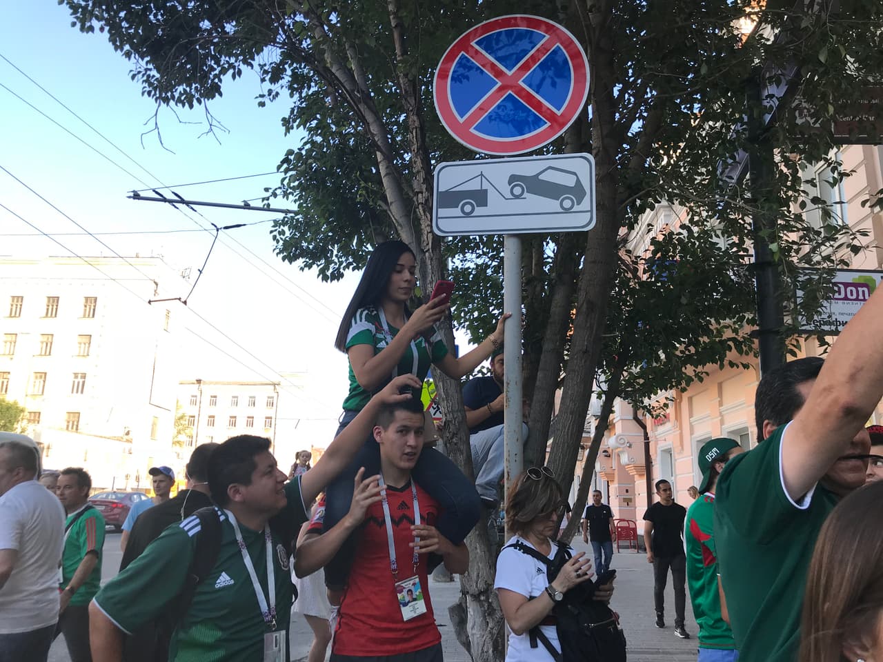 A un lado de la señal de no estacionarse, aficionados mexicanos pasan por las calles de la ciudad de Rostov.