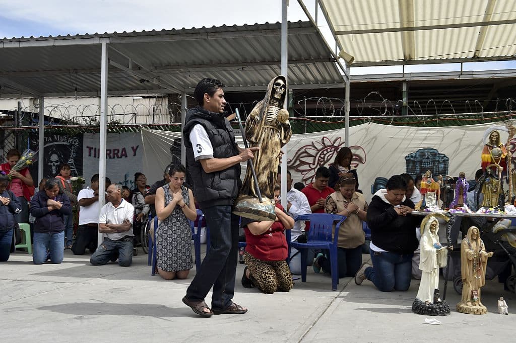 Por ello, le hacen rituales parecidos a los cristianos, incluyendo procesiones y oraciones con el fin de ganar su favor y protección. El altar suele consistir de una estatuilla cuyas medidas van desde 15 centímetros hasta el tamaño normal de un humano, rodeada de distintas ofrendas, como flores, frutas, comida, veladoras, inciensos y particularmente, licor.