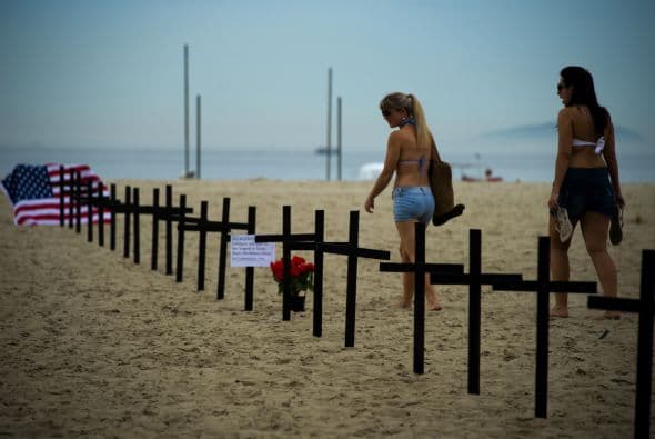 Tras colocar estos materiales, los manifestantes se arrodillaron en silencio ante las cruces.