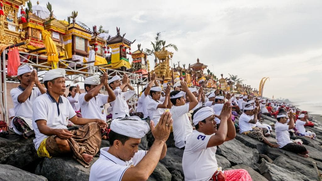 A group of Bali residents pray during the Melasti, a purification ceremony prior to Nyepi, or day of silence.