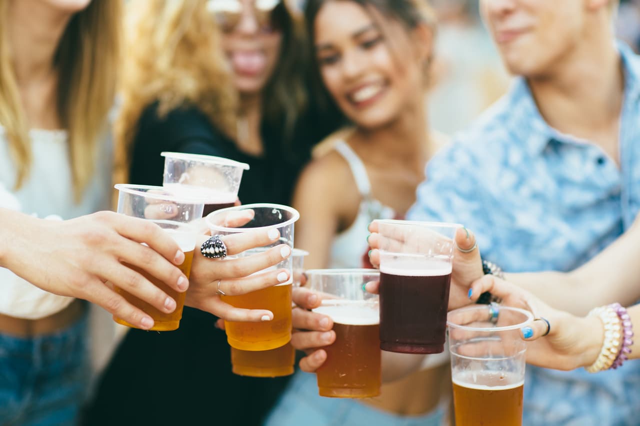 Friends drinking beer and having fun at music festival