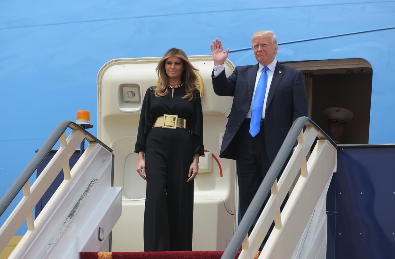 Así apareció Melania Trump en las escalerillas del Air Force One a su llegada a Riad, en Arabia Saudita. Con un mono de manga larga de crepe negro y un gran cinturón dorado de hebilla cuadrada. La primera dama es muy aficionada a cortar sus looks con un potente cinturón, pero usualmente suele reforzar alguno de sus puntos fuertes, como llevar los brazos desnudos, un escote pronunciado, o alguna prenda ceñida que muestre su silueta.