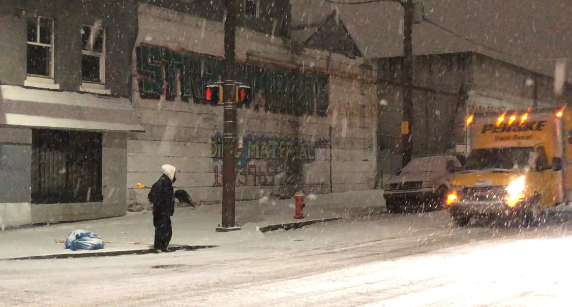 Observamos personas cargando palas, listos para comenzar a remover la nieve del camino.