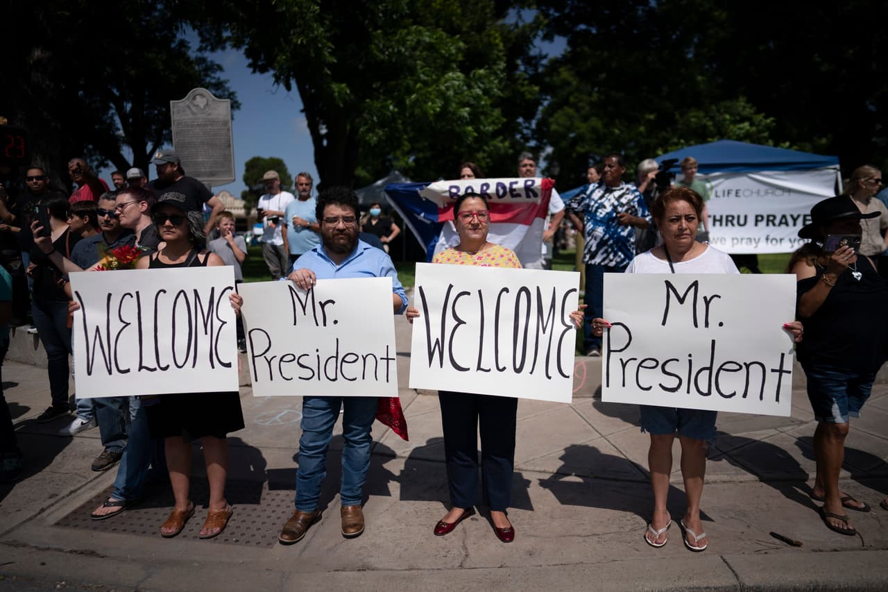 Personas de Uvalde reciben al presidente Biden y a la primera dama con carteles.