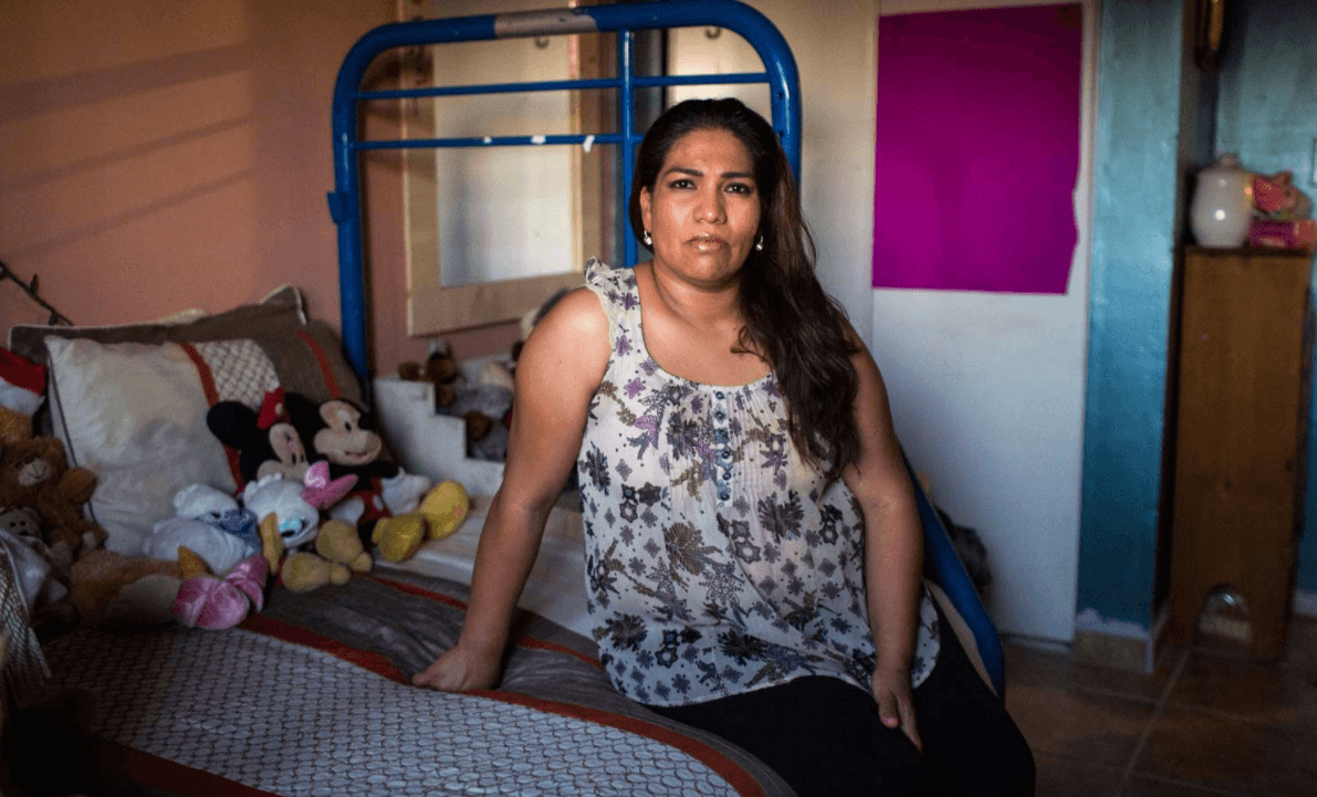 Marcela Herrera posa para una foto en el dormitorio de su hija. La familia recientemente pintó las paredes, instaló suelos de baldosa y puso cortinas para intentar reducir la cantidad de calor que se conserva dentro del apartamento.