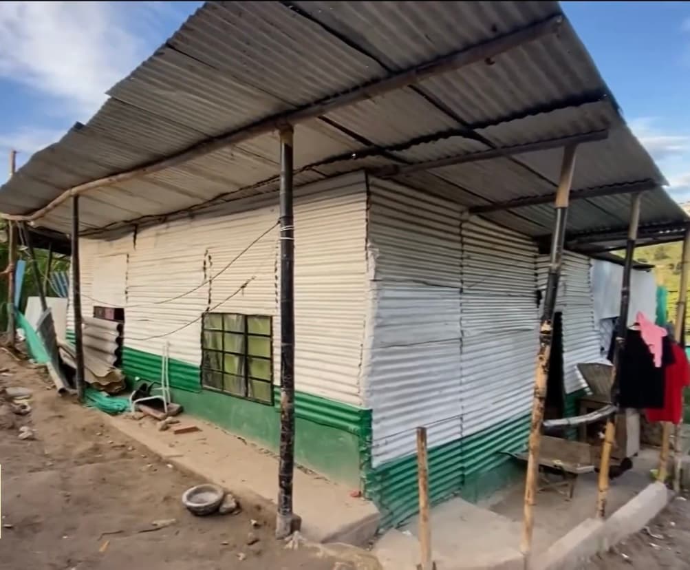 Sin energía eléctrica y sin agua potable, Alfredo vive con sus nietos en una casa de cartón y lata ubicada en una zona de riesgo y altamente inestable dentro del territorio colombiano, desde donde tiene que caminar una milla para atender a sus mejores clientes. 
<br>