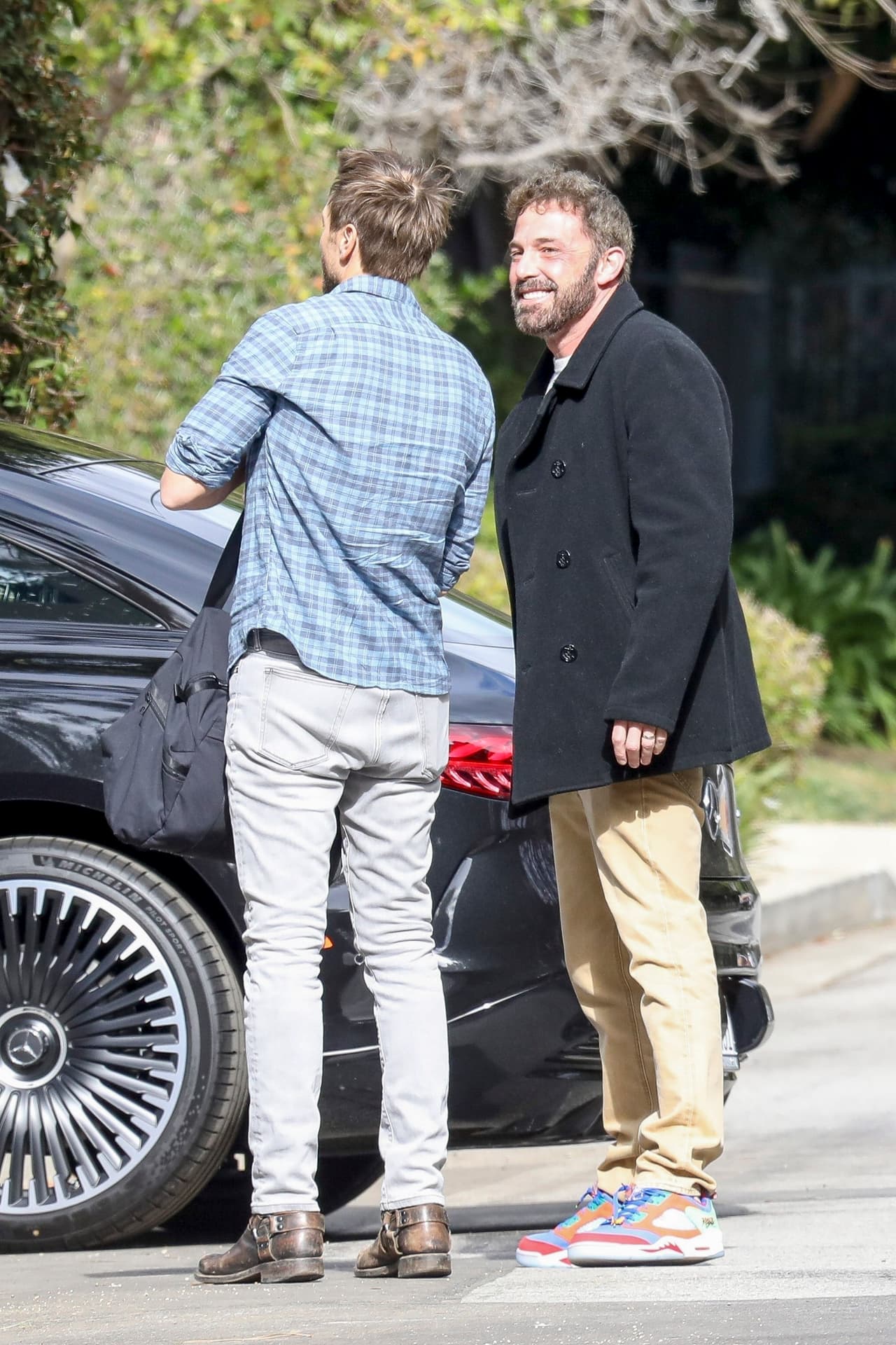 John Miller también estaba vestido casual con camisa azul con estampado de cuadros, jeans deslavados y botines color café.