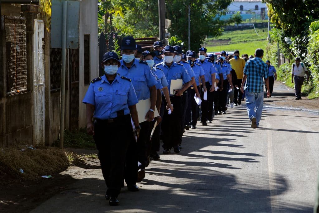 Agentes de policía caminan en fila mientras se dirigen a emitir su voto durante las elecciones generales, en un centro de votación en Managua el 7 de noviembre de 2021.