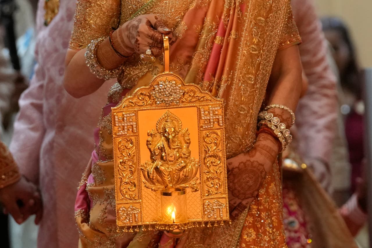 Nita Ambani, esposa del hombre más rico de Asia, Mukesh Ambani, llega sosteniendo una lámpara con una imagen del dios hindú con cabeza de elefante Ganesha, para la boda de su hijo menor, Anant Ambani, el viernes 12 de julio de 2024.