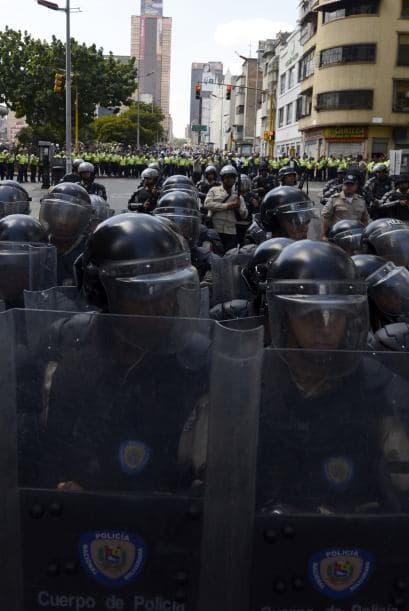 Miembros de la Guardia Nacional se colocan en posiciones estratégicas. Los estudiantes llevaron a cabo una manifestación pacífica contra el régimen del mandatario Nicolás Maduro el 12 de febrero de 2014. Motorizados uniformados y con sus caras cubiertas, dispararon contra los manifestantes, matando a dos estudiantes y a un oficial.