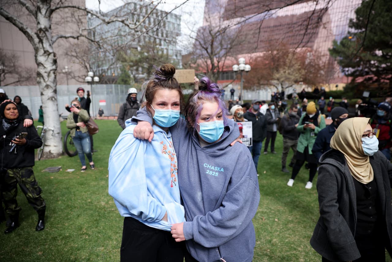 Dos personas se abrazan afuera del centro de gobierno del condado de Hennepin en Minnesota (Minneapolis) después de que el expolicía Derek Chauvin fuera hallado culpable.