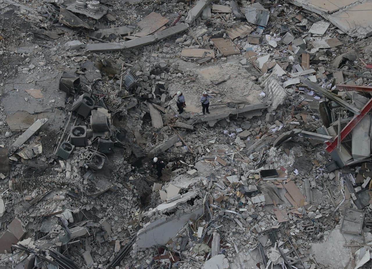 Personal de rescate inspecciona los escombros del edificio en búsqueda de sobrevivientes o víctimas mortales.