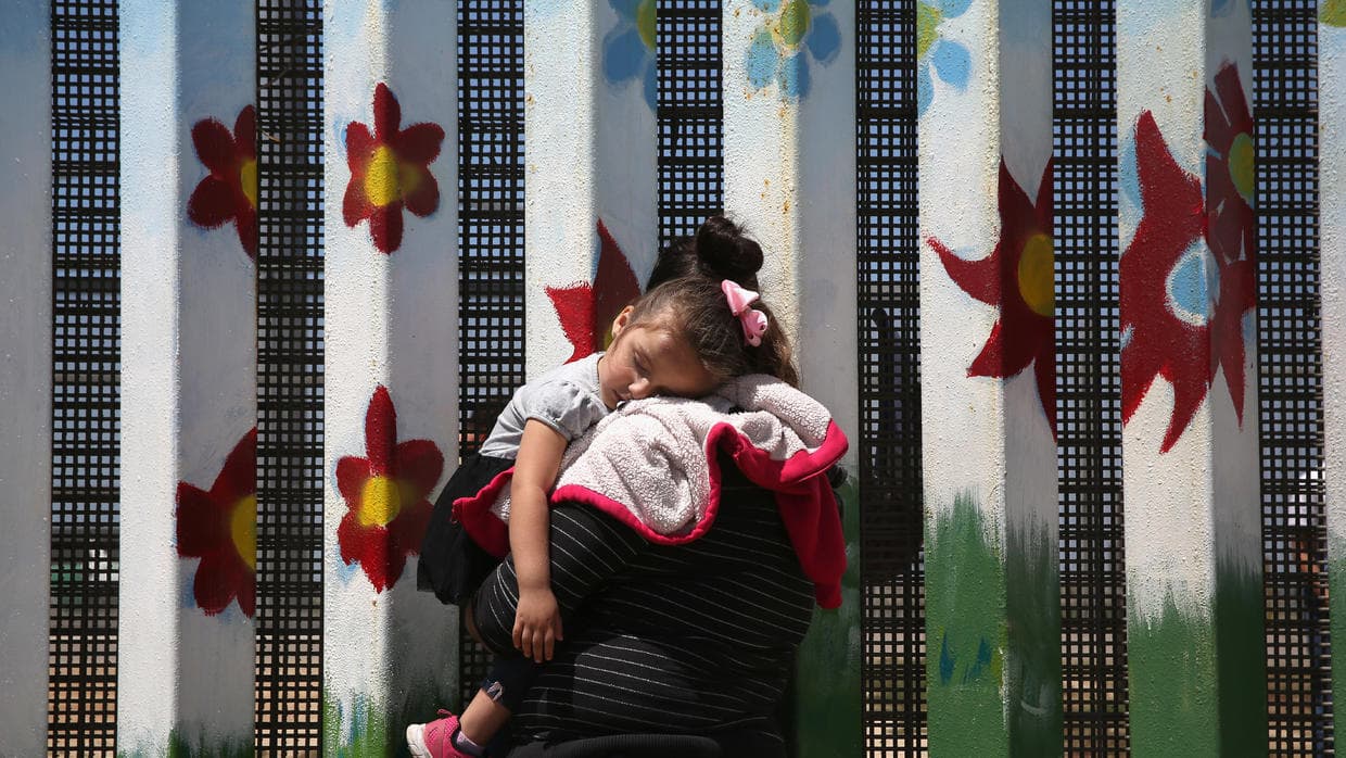 A woman talks to her relatives on the other side of the border.