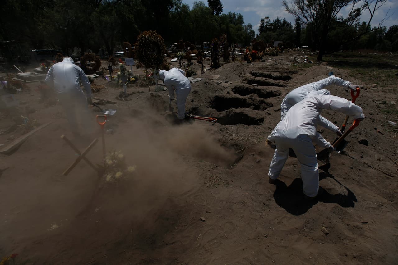 Según los empleados del cementerio San Lorenzo Tezonco, el trabajo durante la pandemia ha sido física y emocionalmente agotador. “Entre el calor y la tierra que nos sofocan… Sepultamos los féretros aún con miedo al contagio. Tenemos familia que proteger”, dijo García.
<br>