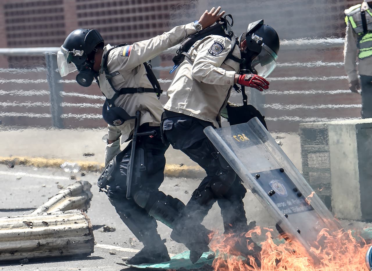Una bomba ‘molotov’ lanzada por manifestantes contra el gobierno de Maduro alcanza a un grupo de policías. Caracas 8 de abril de 2017.