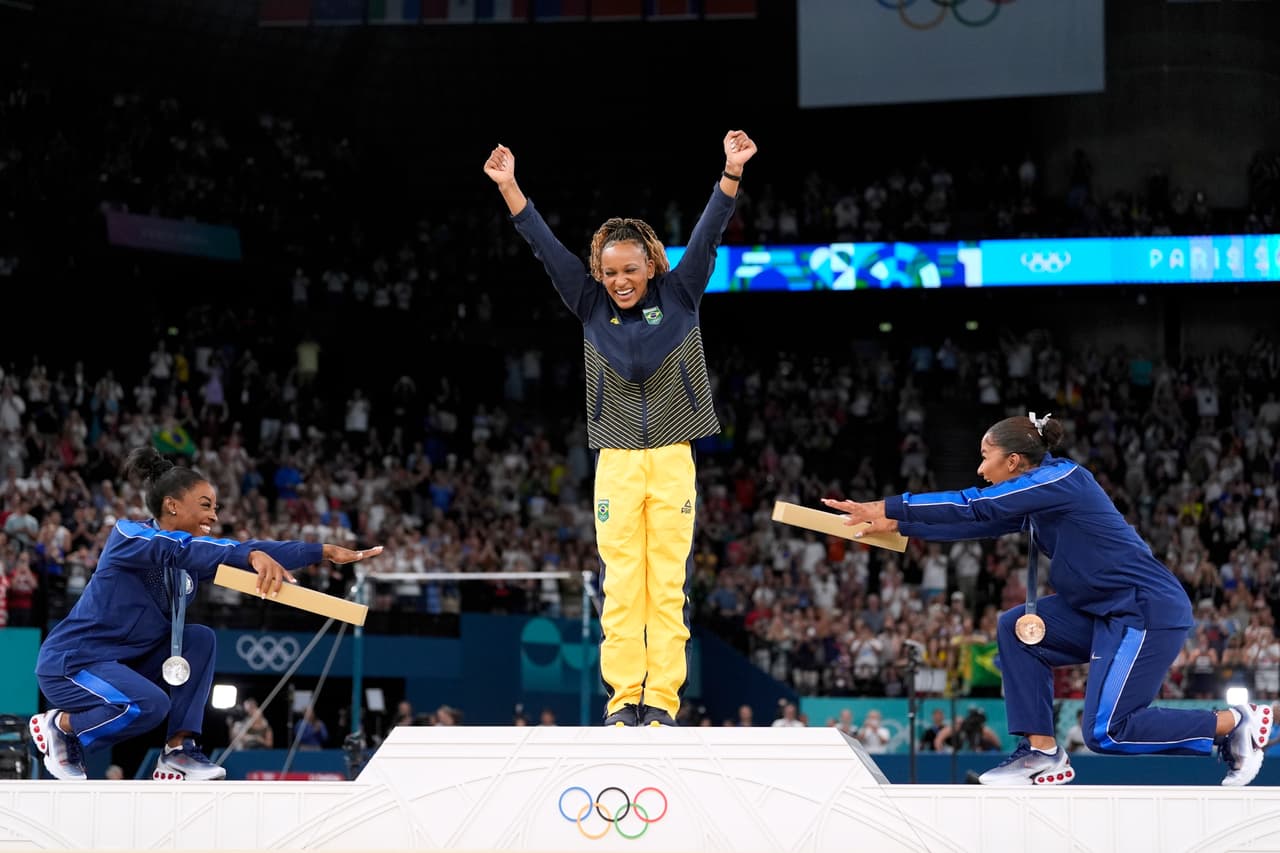 <a href="https://www.tudn.com/juegos-olimpicos/paris-2024/atletas/los-momentos-definieron-paris-2024-unos-juegos-olimpicos-que-viviran-siempre">Simone Biles, a la izquierda con su medalla de plata,</a> y a la derecha, la también estadounidense medallista de bronce, Jordan Chiles, le rinden homenaje a la medallista de oro, la brasileña Rebeca Andrade, en los Olímpicos. Las dos estadounidenses le regalaron esta foto a Andrade, que se volvió viral y pasará a la historia en el podio: respeto y reconocimiento de Biles, la gimnasta más premiada de la historia.