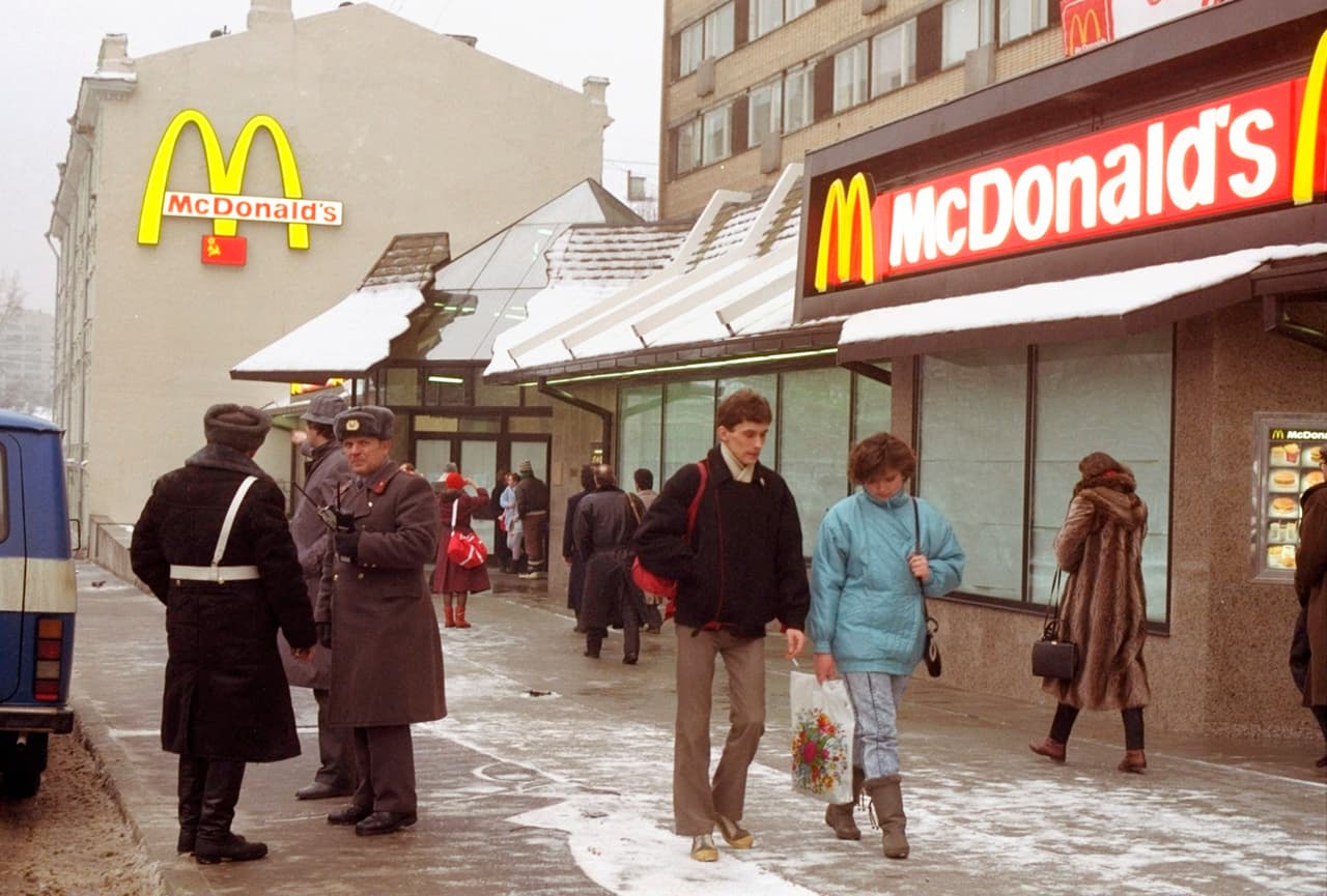 La gente pasa frente al primer McDonald's de Moscú un día antes de su apertura, en la Plaza Pushkin de Moscú, el 30 de enero de 1990. Dos meses después de la caída del Muro de Berlín, McDonald's abrió sus puertas en el centro de Moscú. Fue el primer restaurante estadounidense de comida rápida en ingresar a la Unión Soviética. Pero ahora, McDonald's está cerrando temporalmente sus 850 restaurantes en Rusia en respuesta a la invasión de Ucrania.
