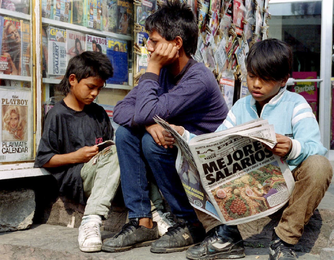 <b>La esperanza de muchos. </b>En 1993, se negociaron y firmaron los acuerdos paralelos entre los tres países. En noviembre de ese año, la Cámara de Representantes y el Senado de Estados Unidos aprobaron el tratado . Ese mismo mes fue refrendado en el Senado de México. En esta fotografía de noviembre de 1993, unos niños de Ciudad de México revisan los diarios con los titulares sobre la aprobación del acuerdo.