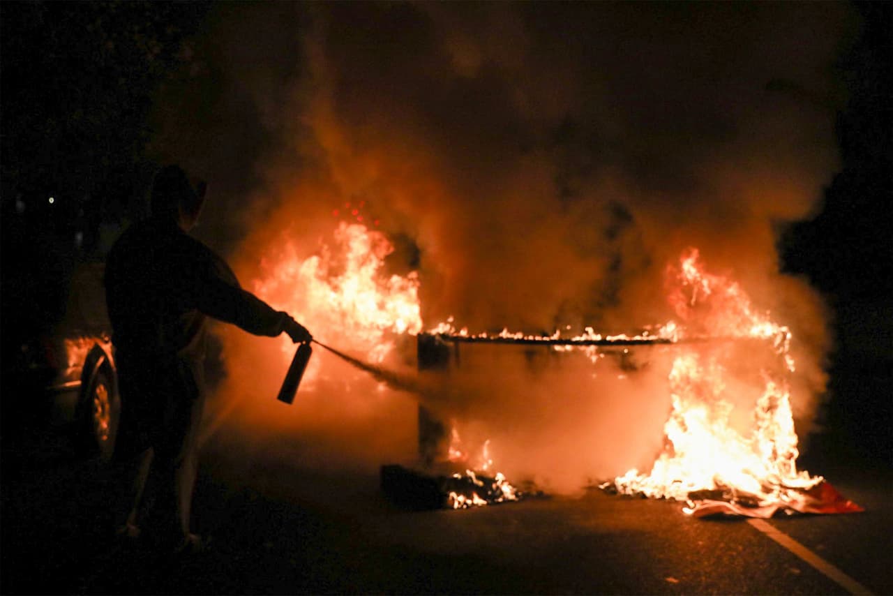 Una persona usa un extintor de incendios para apagar una barricada en llamas en Filadelfia donde el caos y eclipsó el 
<a href="https://www.univision.com/local/philadelphia-wuvp/la-policia-de-filadelfia-aumentara-su-presencia-en-medio-de-disturbios-civiles-tras-la-muerte-de-walter-wallace">mensaje de justicia </a>que cientos de personas llevaron en horas de la tarde.