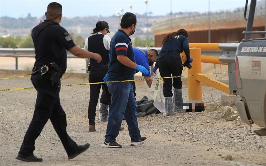 Trabajadores de servicios periciales y del equipo de bomberos rescatan el cuerpo de una niña migrante en las orillas de río Bravo, en Ciudad Juárez.
