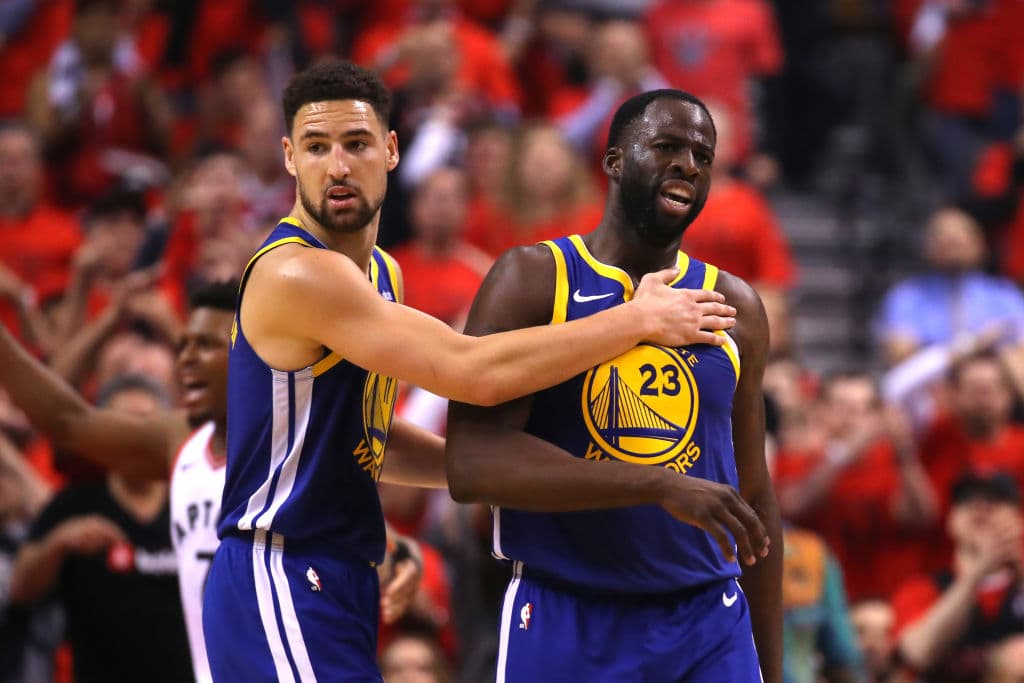 Klay Thompson tratando de calmar a Draymond Green (23) luego de que le cobraan una falta técnica.