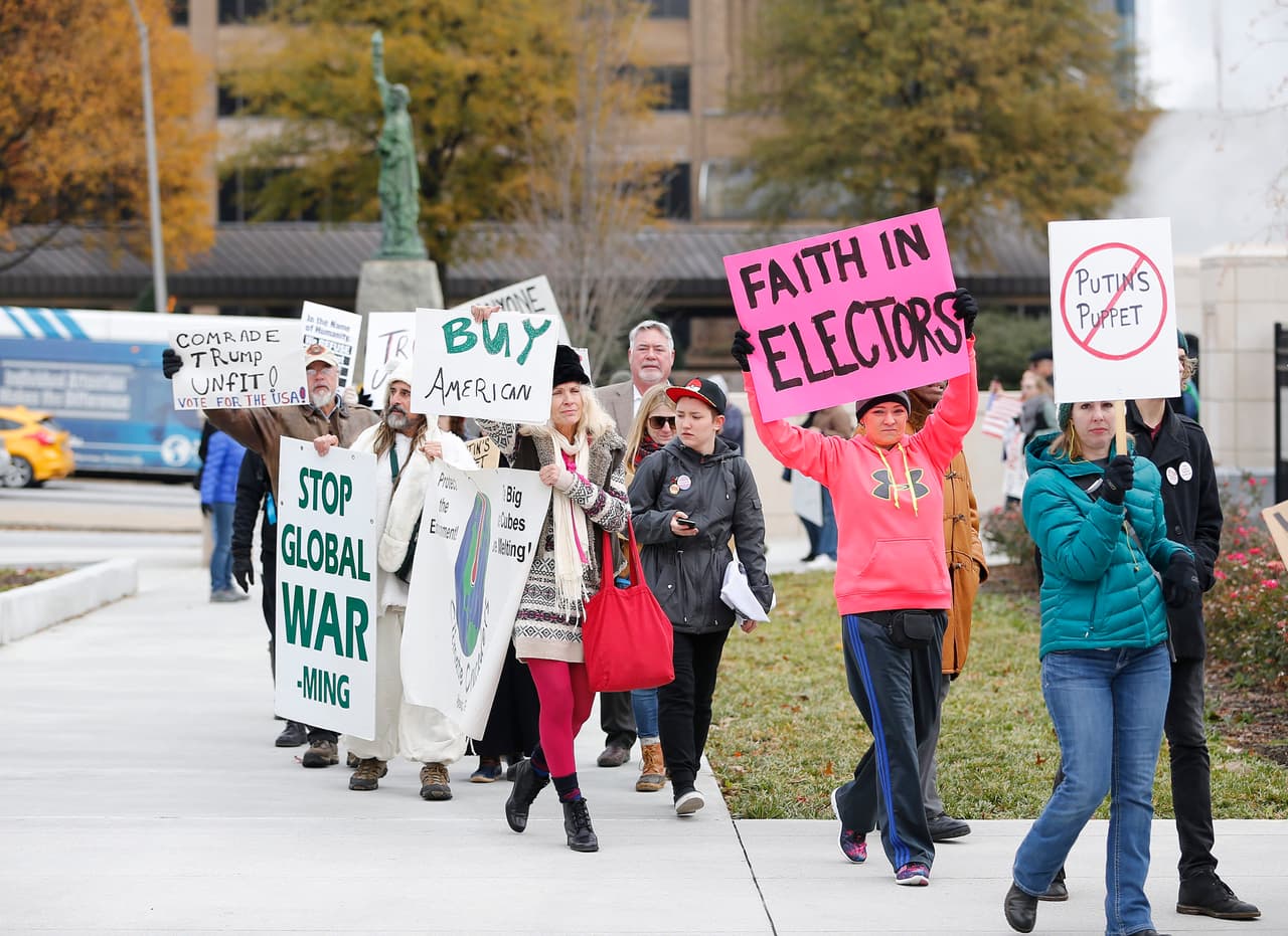 Ciudadanos estadounidenses se manifiestan afuera del Capitolio Estatal de Georgia, antes del encuentro de los dieciséis electores del estado, que emitirán sus votos este 19 de diciembre de 2016. El Colegio Electoral de EE.UU se reúne este lunes para certificar la victoria del republicano Donald Trump.
