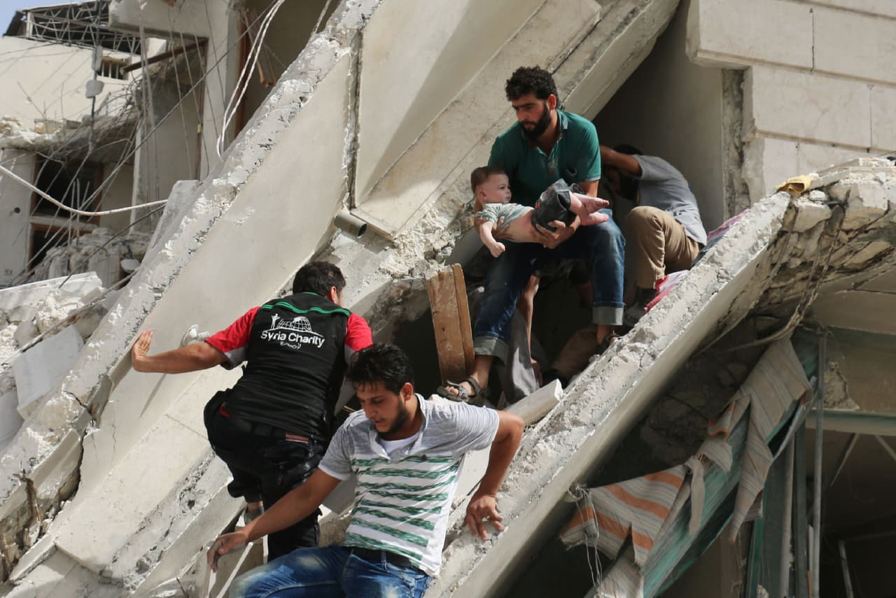 Civiles sirios sacan a un bebé de los escombros de un edificio destruido tras un ataque aéreo sobre el barrio de Qatarji al norte de Alepo, el 21 de septiembre de 2016.