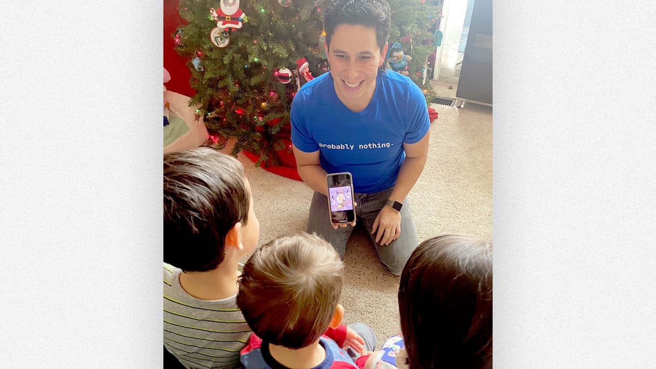 Santiago Gonzales show his children one of his Wall St Bull NFTs.