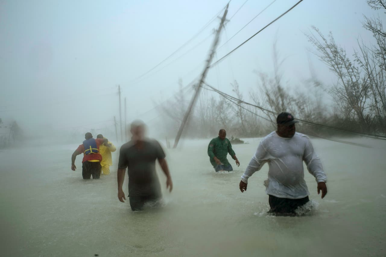 Rescatistas voluntarios caminan por una carretera inundada en busca de familias en Freeport, Gran Bahama. Dorian se mantuvo sobre el archipiélago alrededor de un día y medio.
<br>