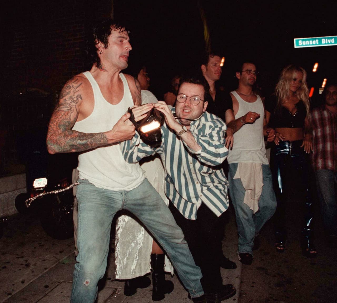 No obstante, Tommy se excedió y empujó y tiró a un fotógrafo.