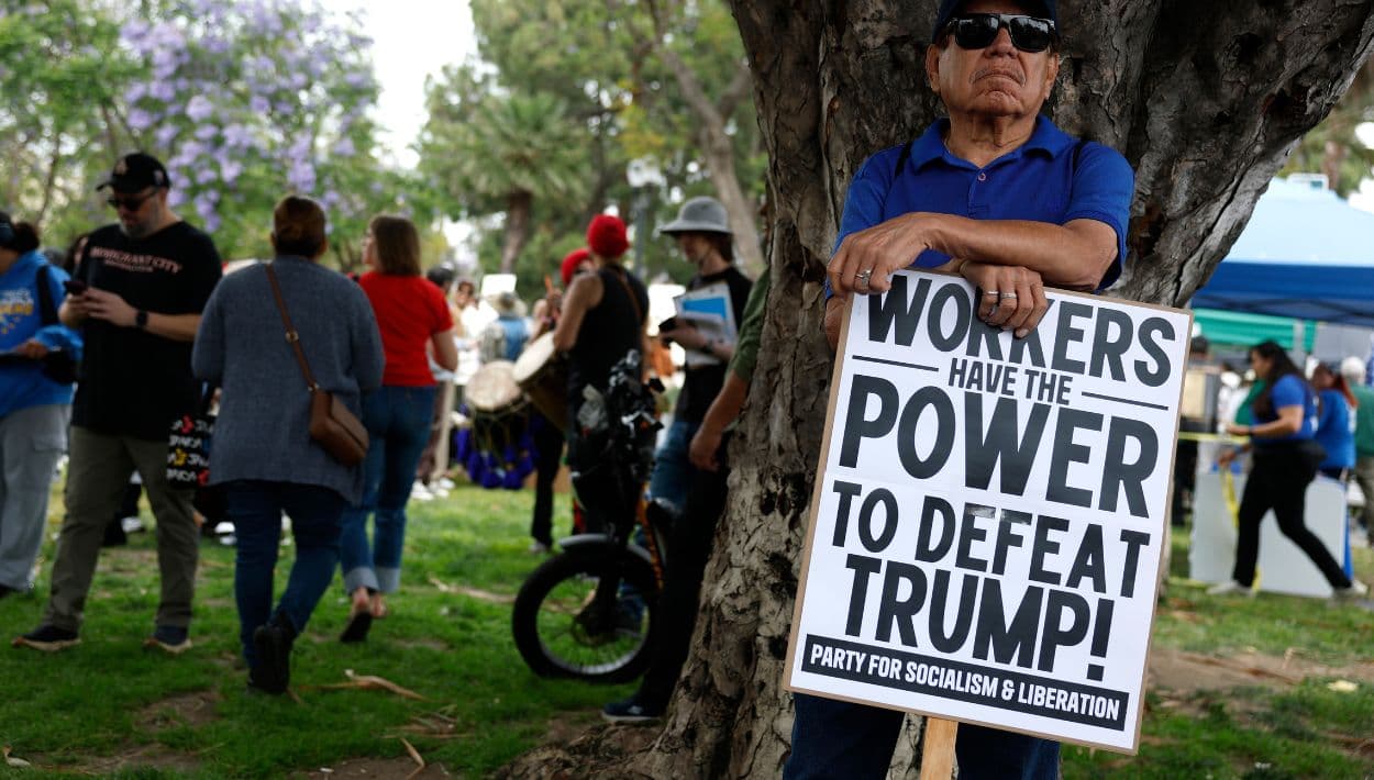 Un manifestante sostiene un cartel durante una protesta el mensaje: “Los trabajadores tienen el poder de derrotar a Trump”.
<br>